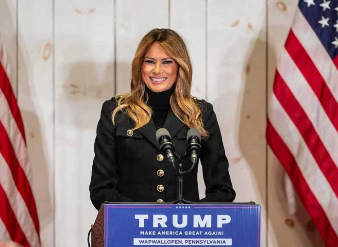 woman speaking at podium with microphones and US flags
