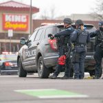 Flock Camera Flag, Near-Disaster Police officers gather beside a patrol SUV at a taped-off scene