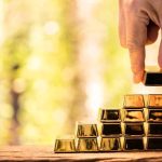 Sewer Workers Hit Gold, Lawyers Swarm Hand stacking small gold bars into a pyramid
