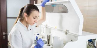 Lab technician using an analyzer with a pipette