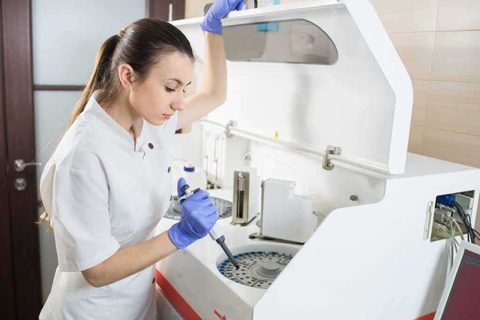 shutterstock_296643947 Lab technician using an analyzer with a pipette