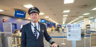 High Pilot Lands With 70,000 Pills Airline pilot standing in airport check-in area with rolling bag