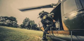 Mass Rescue Stuns Nigeria Soldier boarding a helicopter during field operation