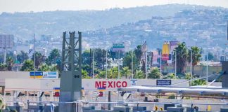 Border crossing booths at Mexico entry point with cityscape in background