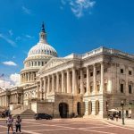 United States Capitol building with dome and columns under a blue sky