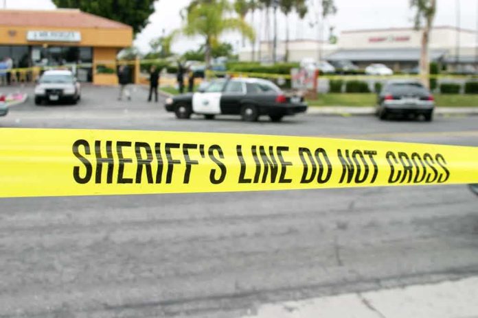 yellow sheriff's line tape blocks a street near police cars