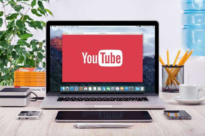 293731811-1 YouTube logo on a laptop screen on desk.