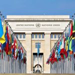 Sovereignty Shock: Trump Draws Hard Lines United Nations building with numerous national flags outside.