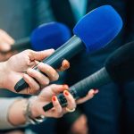 New Hampshire Wildcard Could Flip Senate Reporters holding colorful microphones