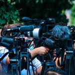 New Tire Rule Blindsides Drivers TV news cameras crowding together at an outdoor event