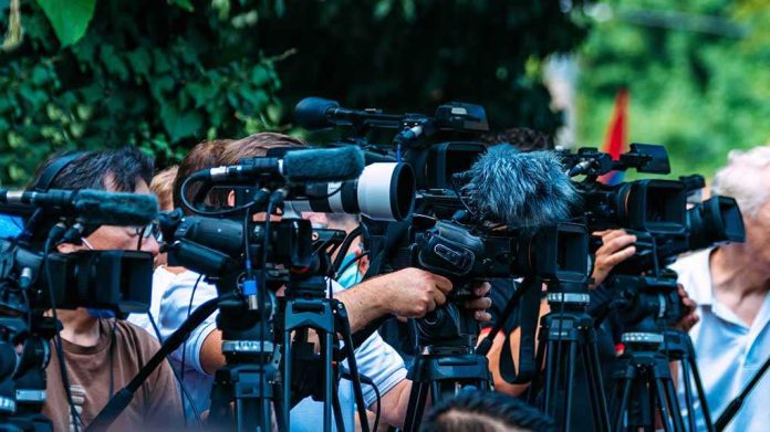 default-hero-03-2 TV news cameras crowding together at an outdoor event