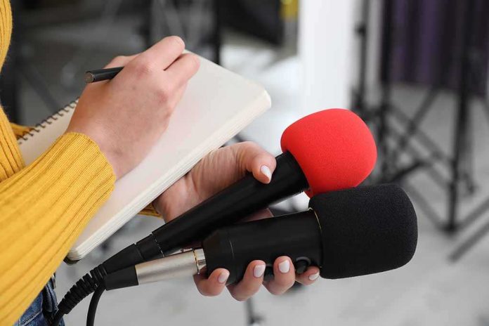 default-hero-05 Journalist holding two microphones while writing in a notebook