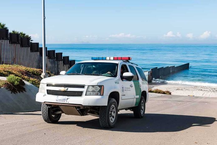 shutterstock_1016615035-1 Border patrol SUV parked near beach fence