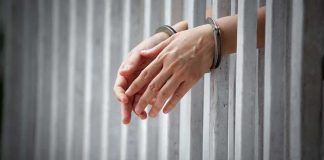 Execution Halted Last Minute handcuffed hands resting through prison bars