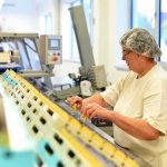 Jobs Up, Hiring Beats Forecasts Worker in hair net inspects items on a factory conveyor line