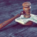 Defamation War Erupts Over Crime Drops Judge's gavel resting on a stack of US dollar bills