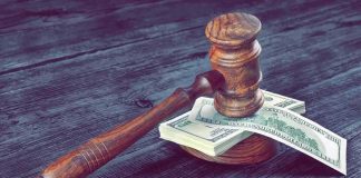 Defamation War Erupts Over Crime Drops Judge's gavel resting on a stack of US dollar bills