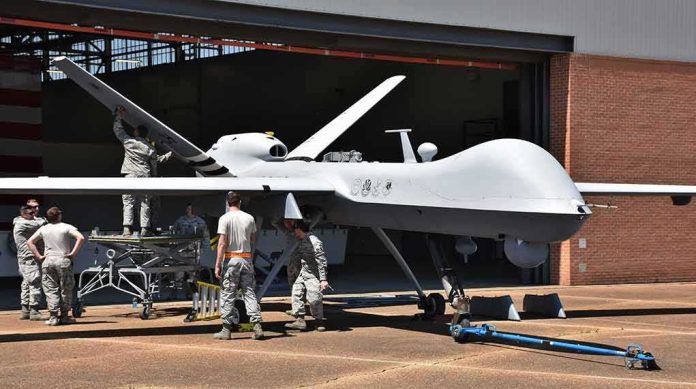 shutterstock_1079246960 Military drone being serviced by ground crew outside a hangar