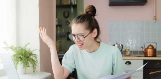 Trillion-Dollar Aid, Misleading Divide Young woman with glasses frustrated at laptop while holding bills