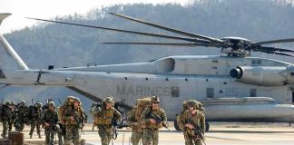 Cyber Recruits Score $15K – Why Now? Soldiers disembark and walk past a large military helicopter