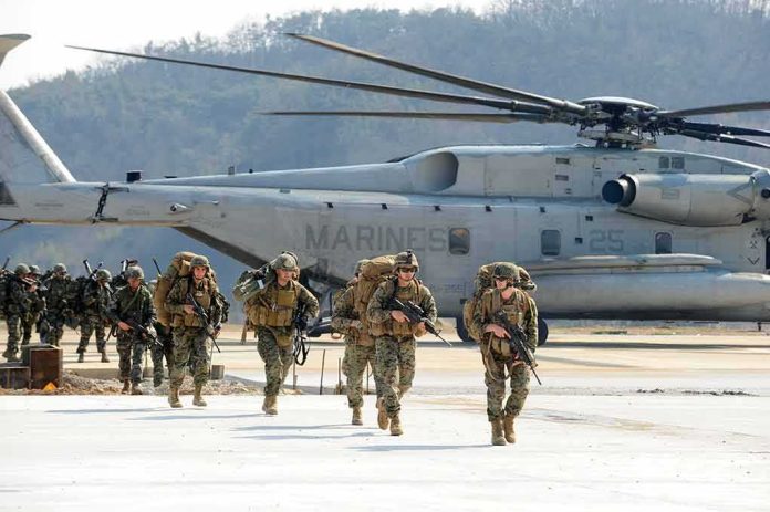 shutterstock_1123252001-1 Soldiers disembark and walk past a large military helicopter