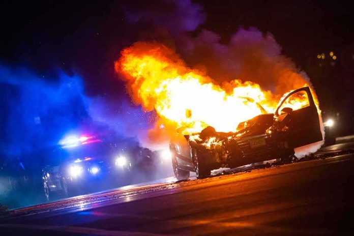 Burning car on a dark street at night