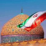 Iranian flag waves before an ornate mosque dome at sunset