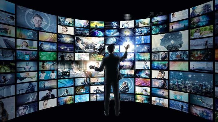 shutterstock_1149399665 Person interacting with curved wall of digital screens