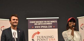 Curro Savoy at a TPUSA event with another speaker on stage