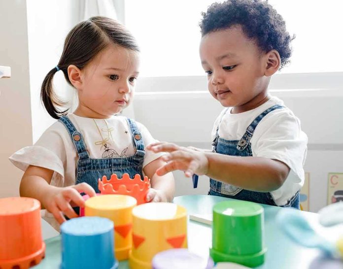 shutterstock_1240406644 Toddlers playing with colorful stacking cups at a table