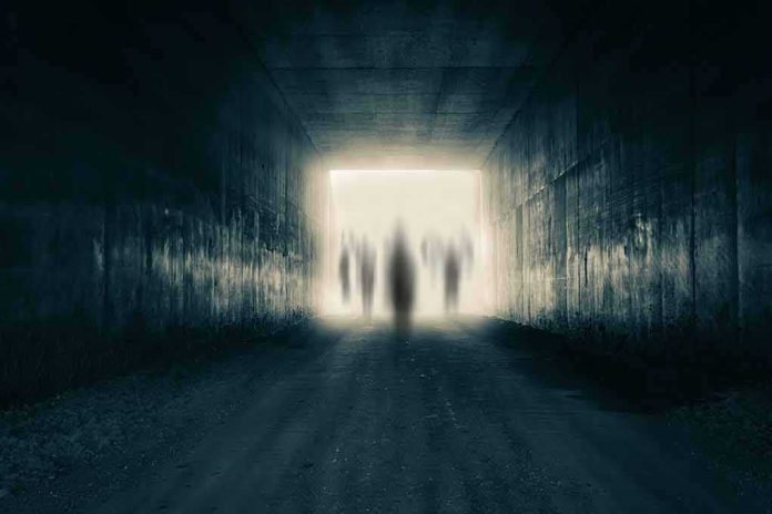 Silhouetted figures at the end of a dark tunnel