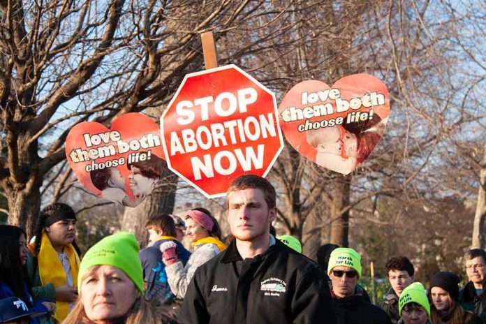 shutterstock_1290632095 Protesters holding anti-abortion signs at an outdoor rally