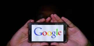 Hands holding a smartphone displaying the Google logo