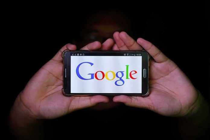 Hands holding a smartphone displaying the Google logo