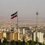 Iranian flag over Tehran skyline with Milad Tower