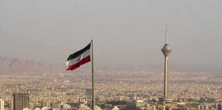 Iran’s Checkpoints Explode Across Cities Iranian flag over Tehran skyline with Milad Tower