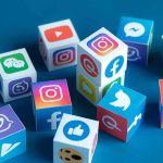 Social media icons on colorful cubes scattered on a blue surface