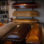 6 Dead Bodies, Many Warnings, Who Missed It? Row of coffins displayed in a funeral home showroom