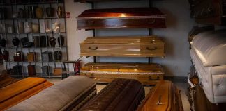 Row of coffins displayed in a funeral home showroom