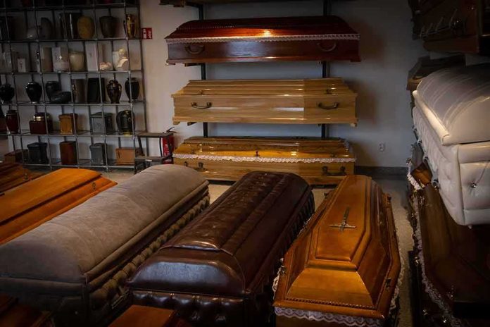 shutterstock_1562591803-1 Row of coffins displayed in a funeral home showroom