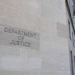 Department of Justice building exterior with American flags