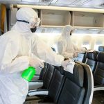 Virus Evacuation Drama: Americans Airlifted! Workers in hazmat suits disinfecting airplane cabin seats