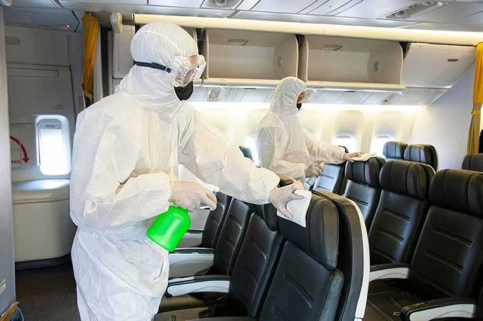 shutterstock_1665040936 Workers in hazmat suits disinfecting airplane cabin seats