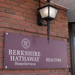 Warren Buffett Steps Down – Dynasty Move? Berkshire Hathaway HomeServices Realtors sign on brick wall