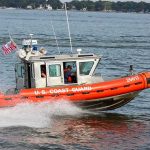 Coast Guard patrol boat speeding across a bay
