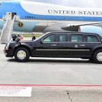 Engine Blows Midair—DHS Boss Aboard Presidential motorcade limousine parked beside large blue and white aircraft