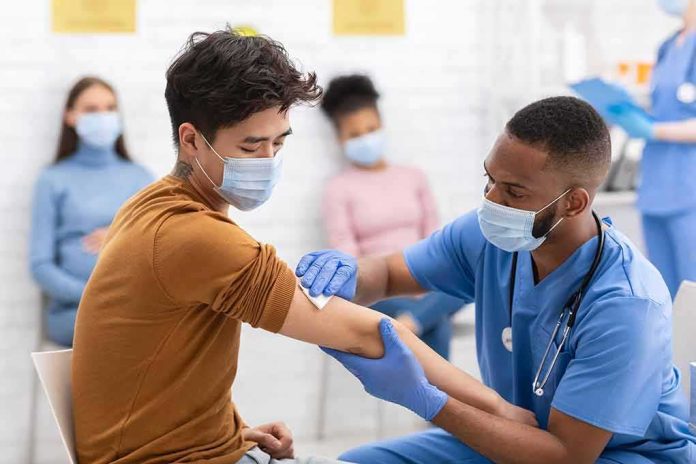 shutterstock_1827506501 Healthcare worker gives vaccination to masked patient in clinic