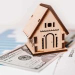 Unanimous Fed Jolt Rattles Borrowers Wooden house model on money and contract papers