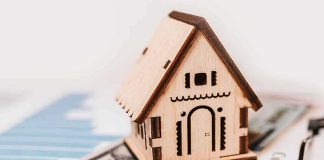 Unanimous Fed Jolt Rattles Borrowers Wooden house model on money and contract papers