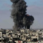 Drone Swarm Slams Russian Oil Hub Thick black smoke rises from an explosion over a dense urban area